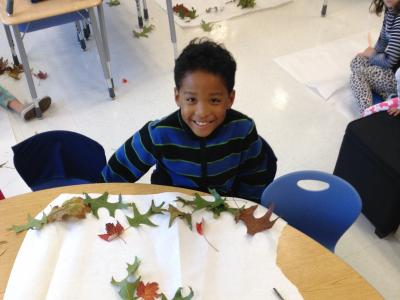 Photo of student making art with nature objects